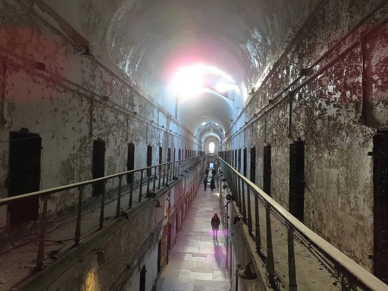 A ruined vaulted cellblock with peeling walls and skylights at Eastern State Penitentiary
