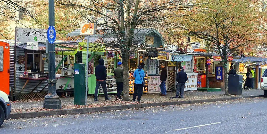 A row of Portland food carts along a paved lot