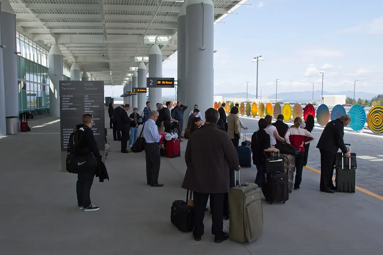 Travelers waiting in a busy airport rental car facility