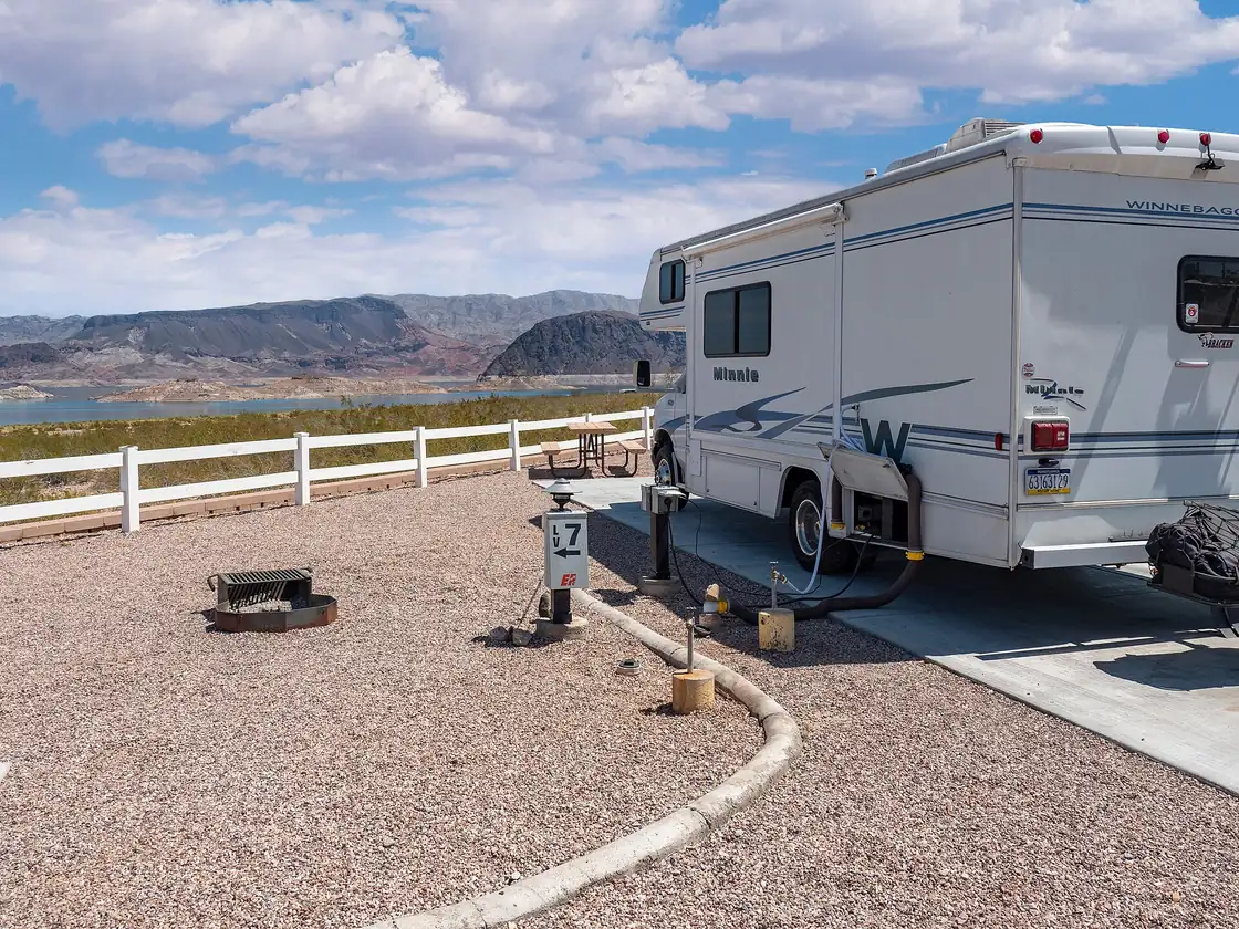 Motorhomes parked at a desert RV park beside a lake in the American Southwest