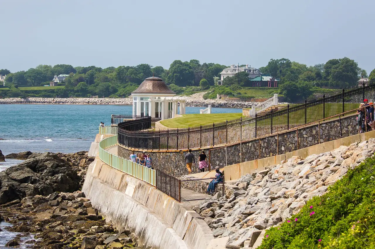 Walkers on Newport's Cliff Walk with the Atlantic and rocky shore below