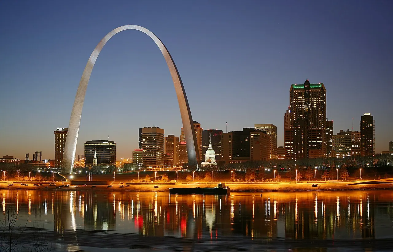 The Gateway Arch lit at night above the Mississippi River in St. Louis