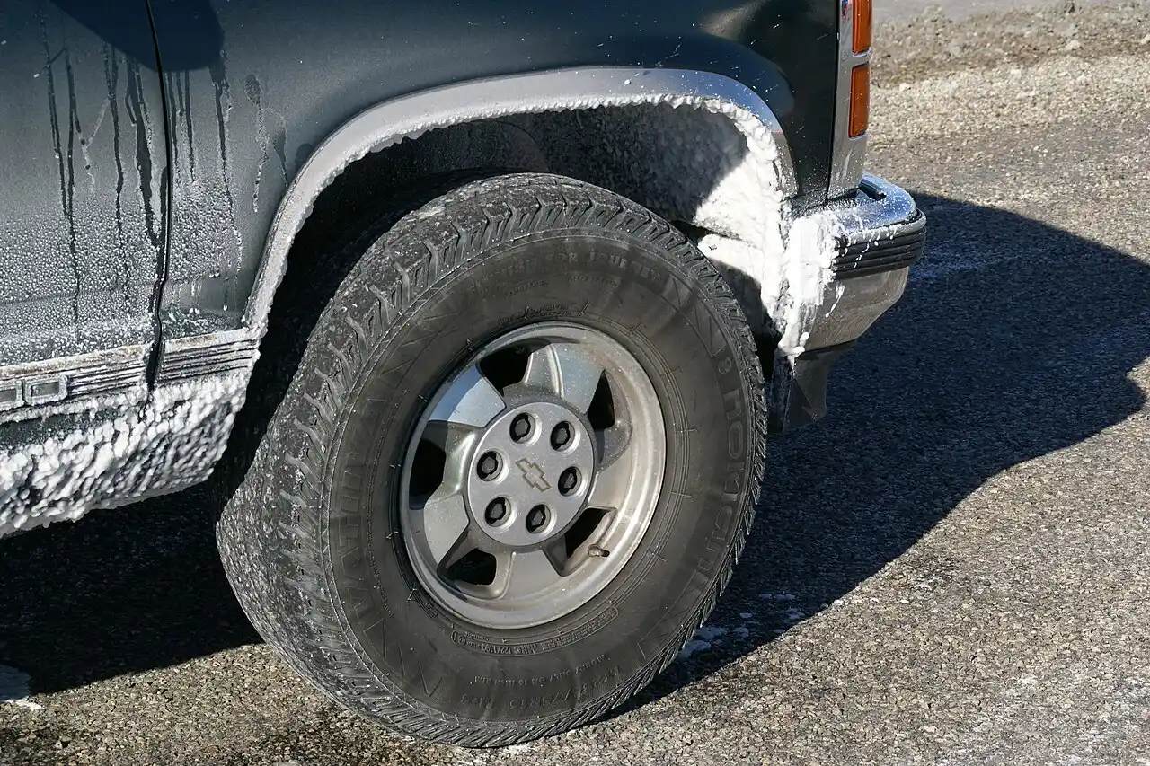 Caked white salt residue coating the wheel well and lower body panel of a pickup truck at the Bonneville Salt Flats