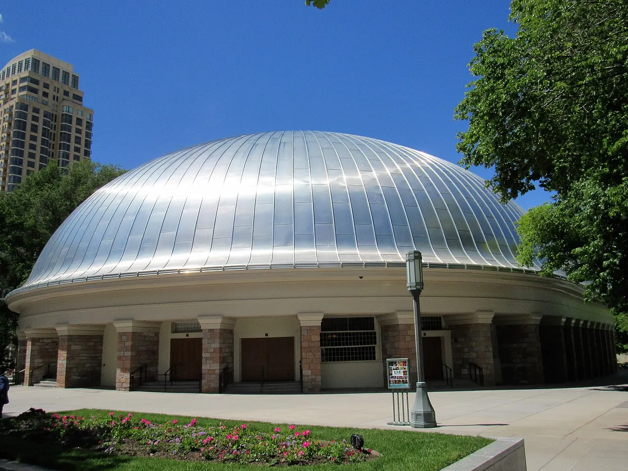 The dome-roofed Salt Lake Tabernacle building with its metal roof reflecting sunlight, in Temple Square