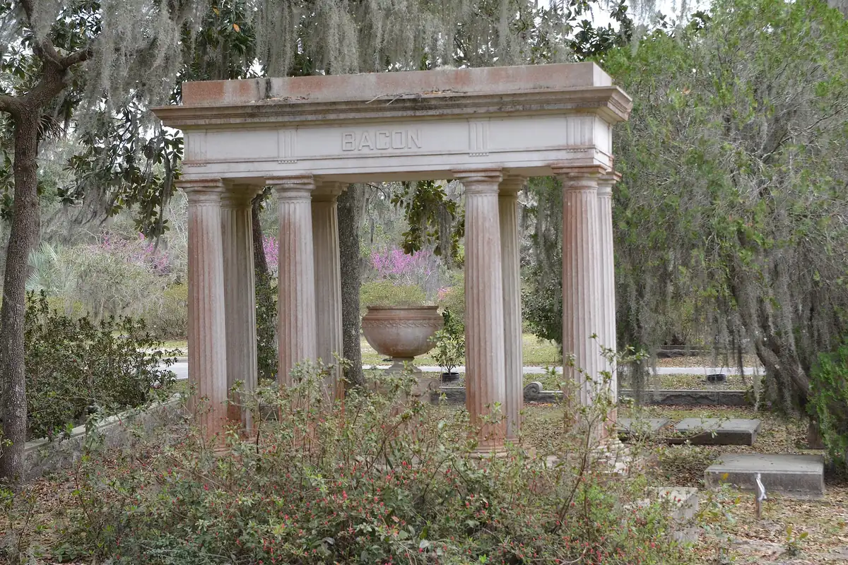 Monument and live oaks along a sandy road inside Bonaventure Cemetery