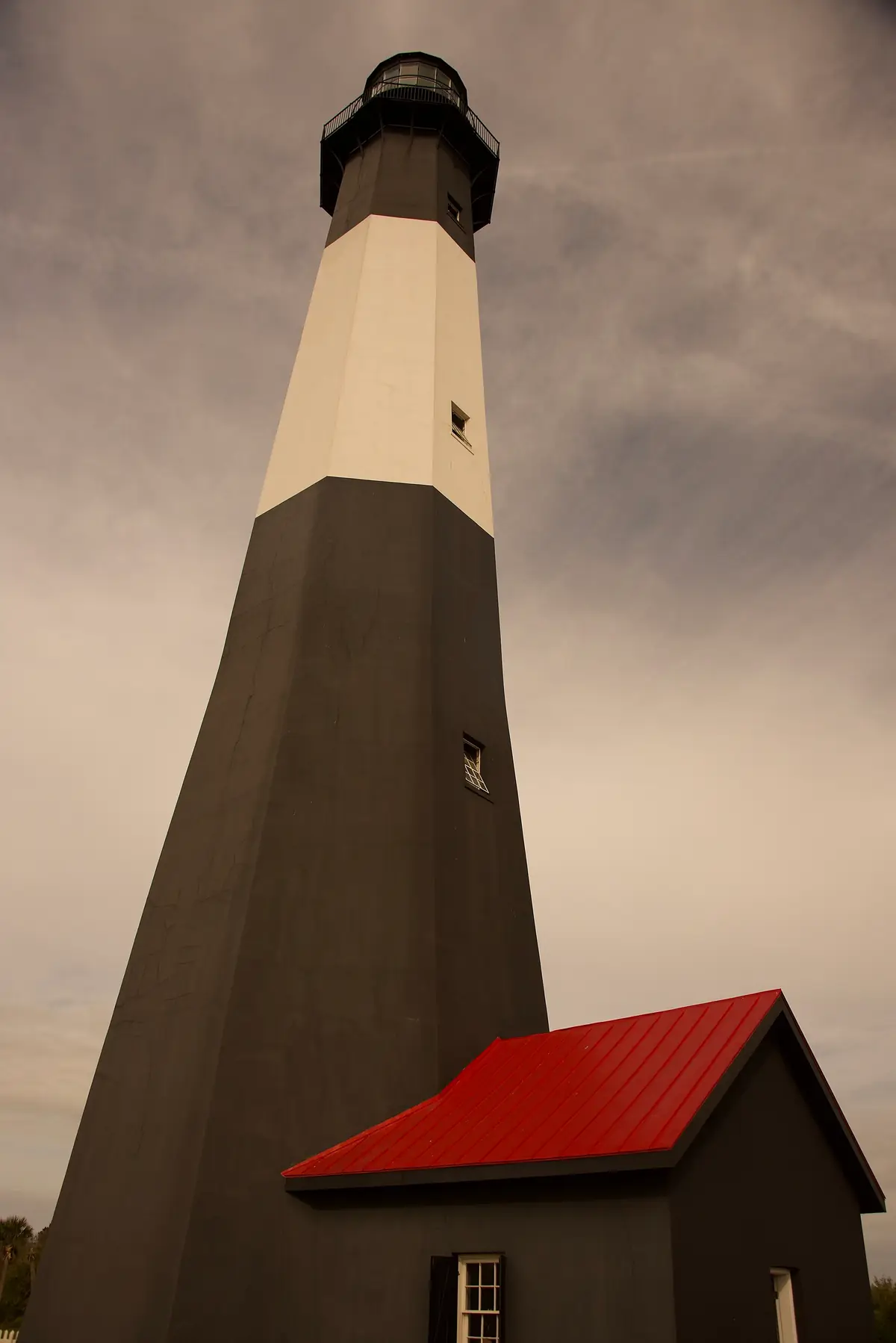 Black-and-white banded Tybee Island Lighthouse against a blue sky