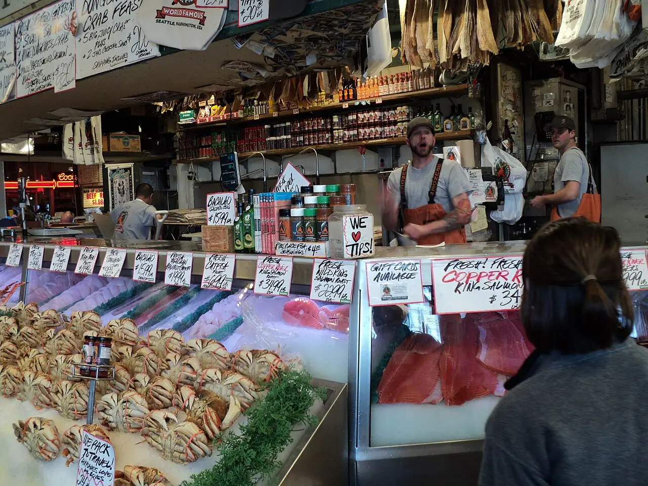 A fishmonger at Pike Place Fish Market waiting to catch a salmon thrown across the counter