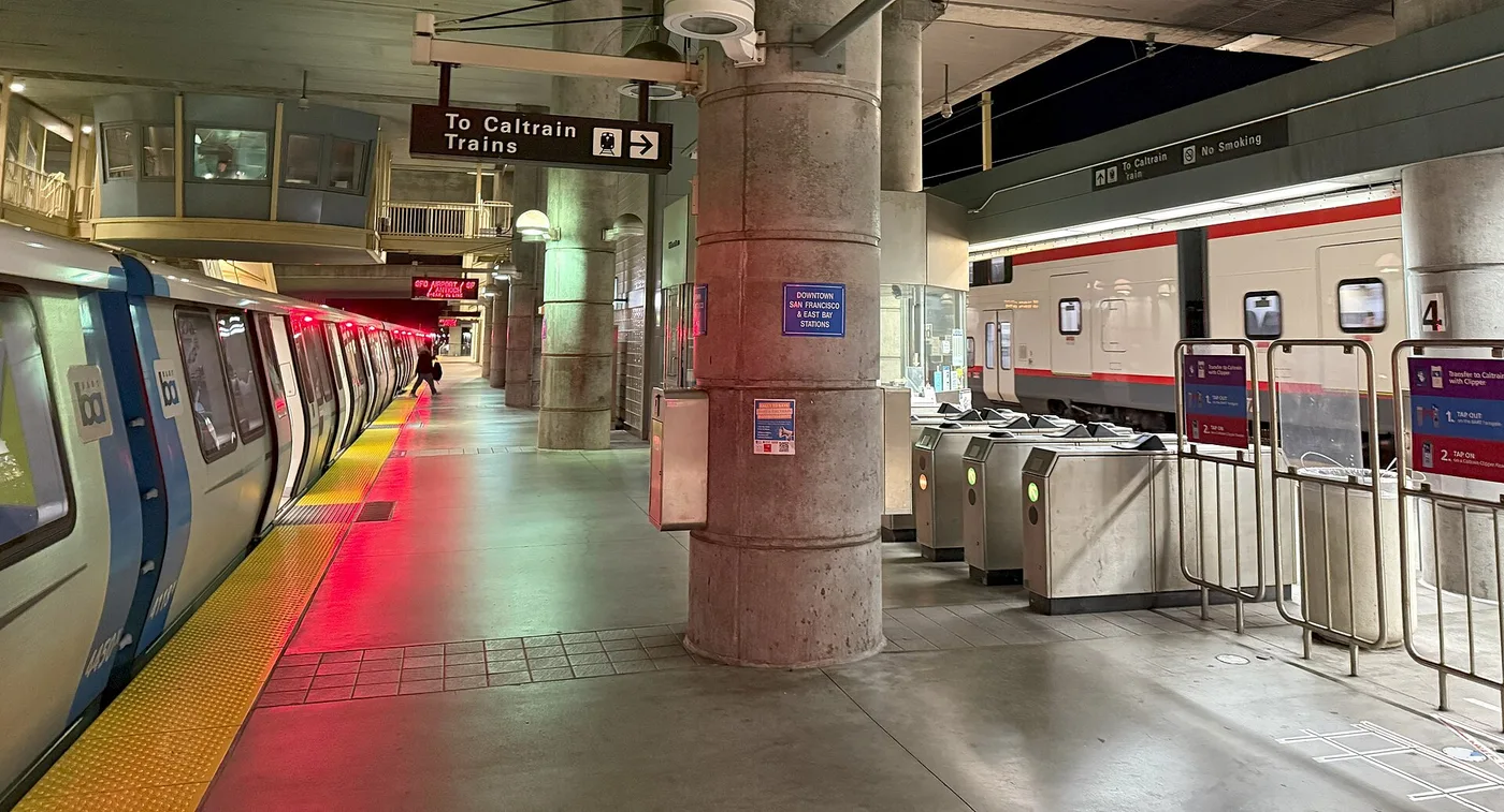 A BART train and a Caltrain train sharing platforms at Millbrae station