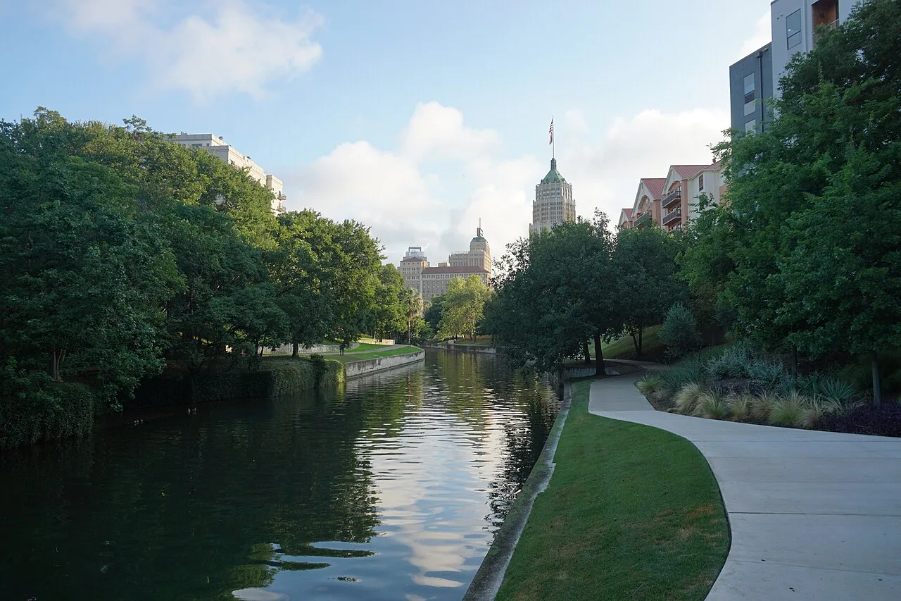 Restaurant terraces and cypress trees along the San Antonio River Walk below street level
