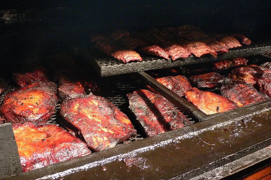 Sliced brisket and beef ribs on butcher paper at a Texas barbecue counter