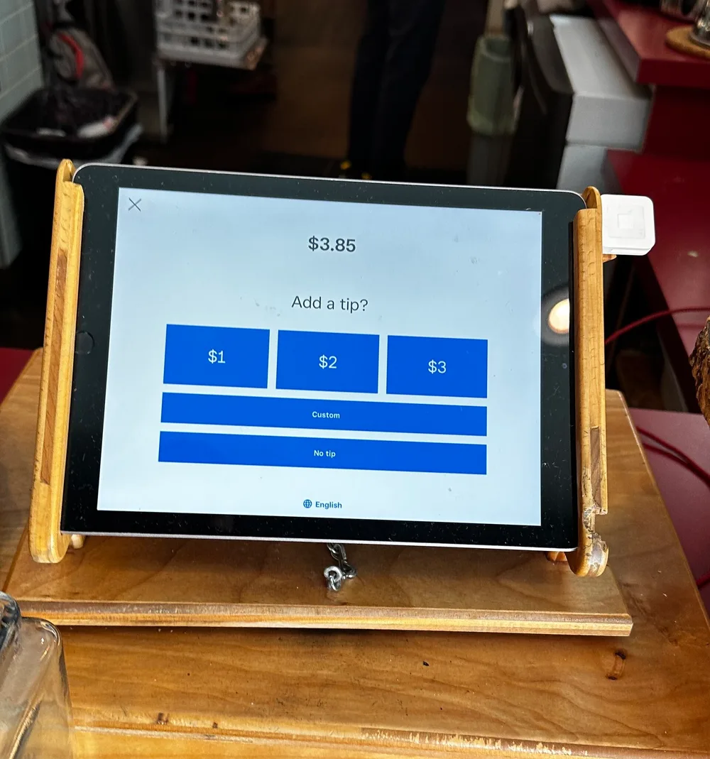 A payment tablet asking for a tip on a $3.85 coffee order