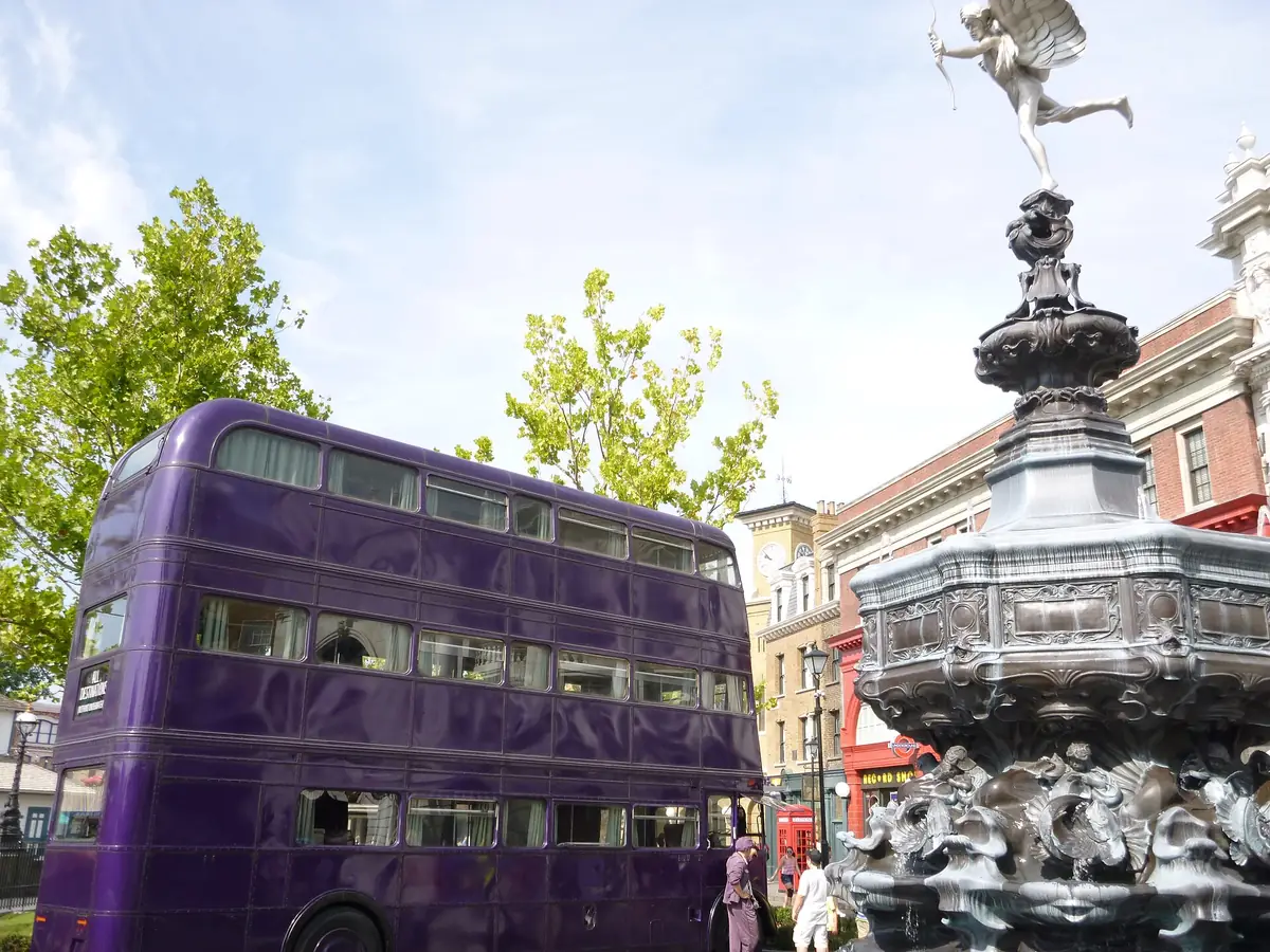 The purple Knight Bus parked beside a fountain in the London waterfront area of Universal Studios Florida