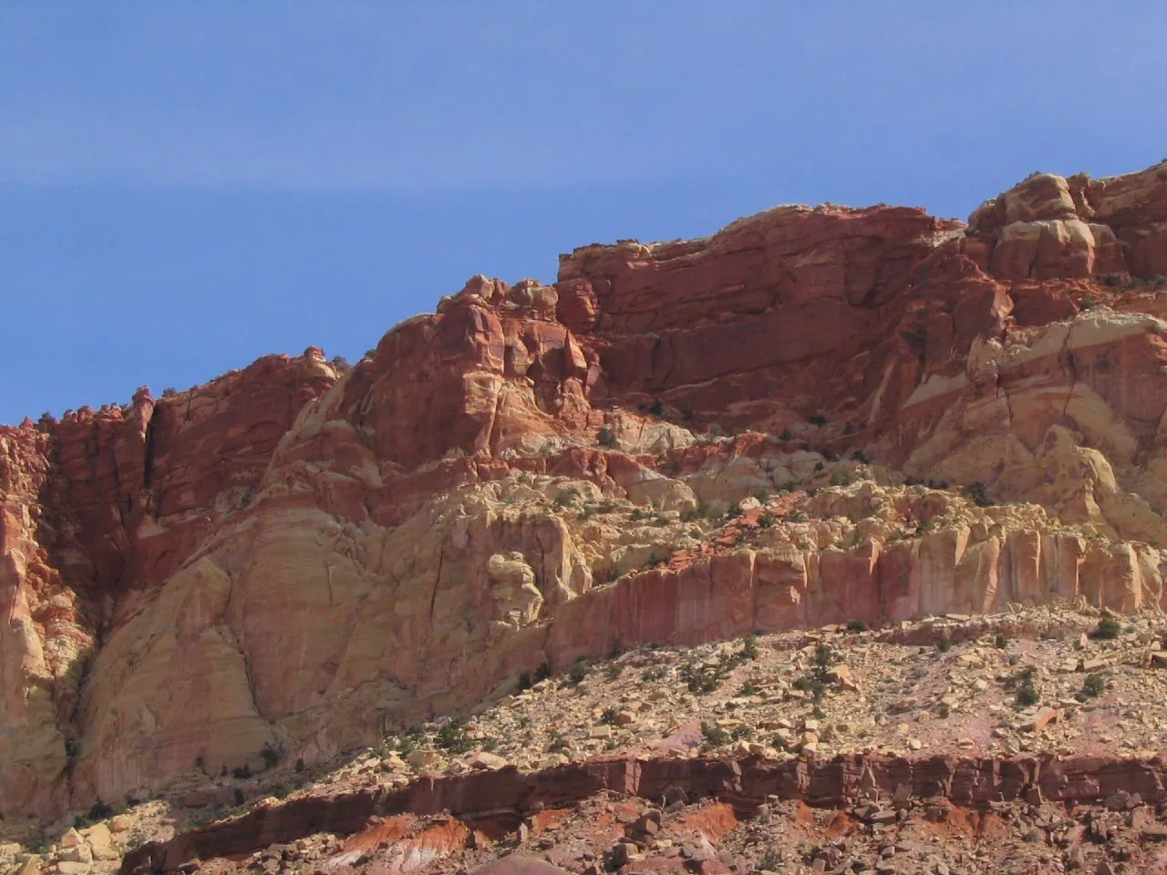 Layered red cliffs and desert vegetation along the Scenic Drive in Capitol Reef National Park, Utah