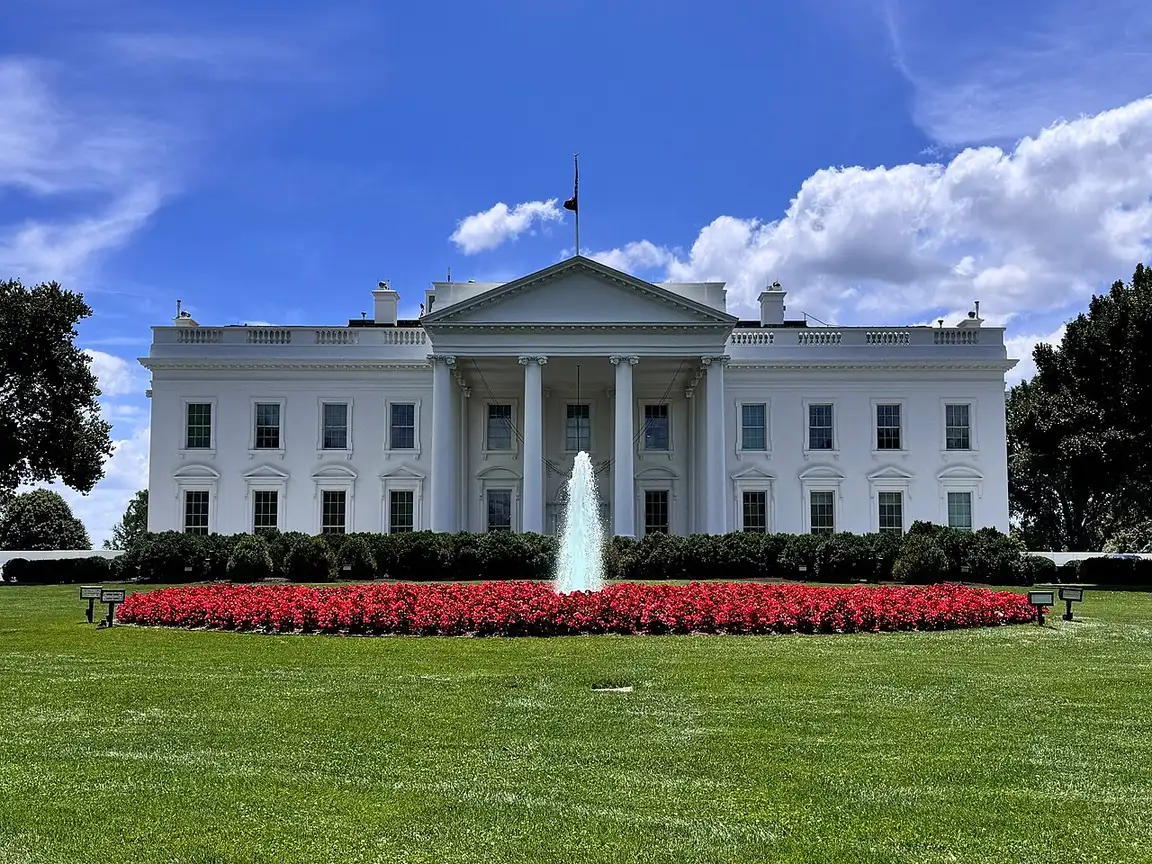 The north facade of the White House behind its lawn and fence