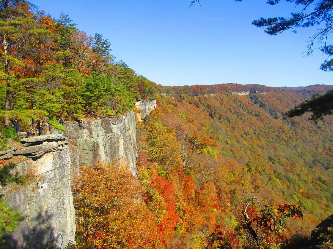 Climbers and hikers along the Endless Wall sandstone cliffs above New River Gorge