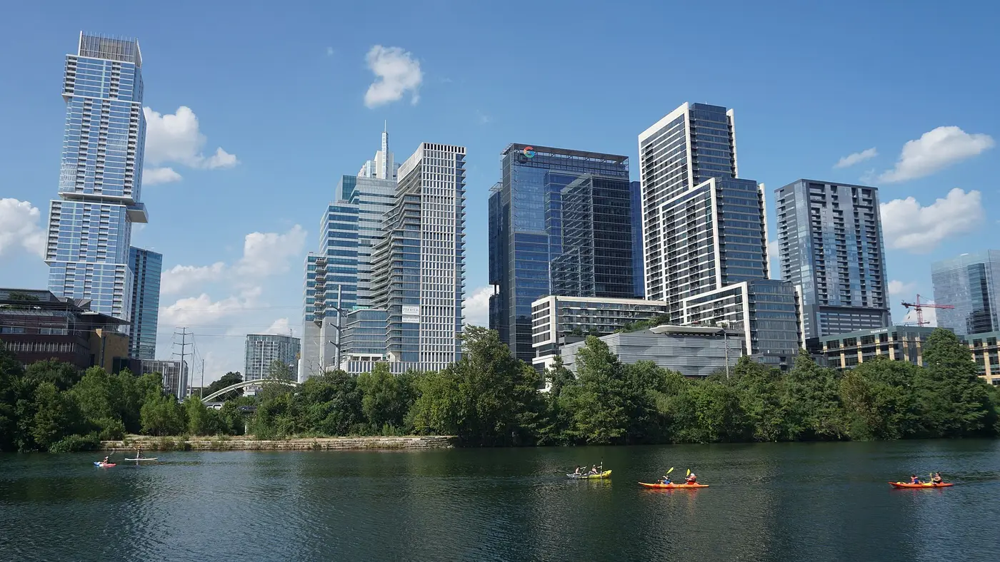 Downtown Austin skyline across Lady Bird Lake under a blue sky