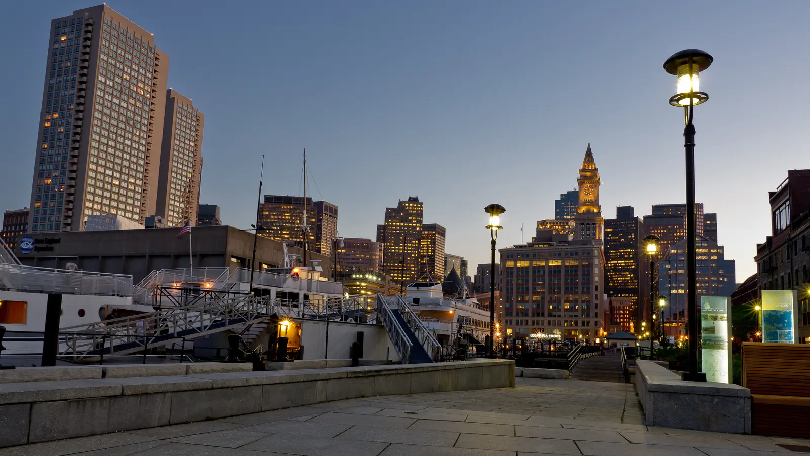 Downtown Boston towers and the Custom House clock seen from Long Wharf at dusk