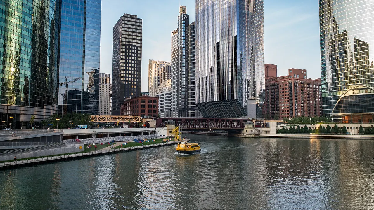 A water taxi on the Chicago River passing downtown towers and the Riverwalk