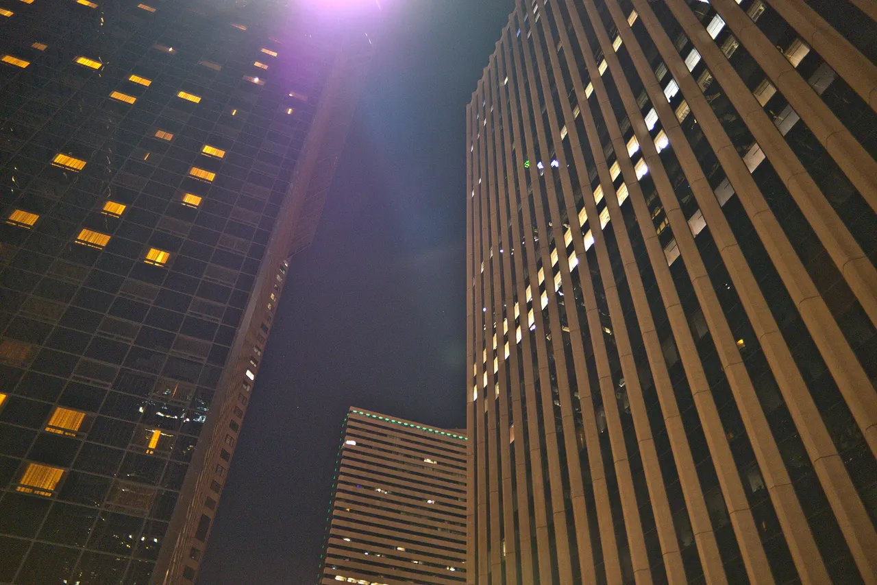 Downtown Denver office towers at night photographed from street level looking straight up