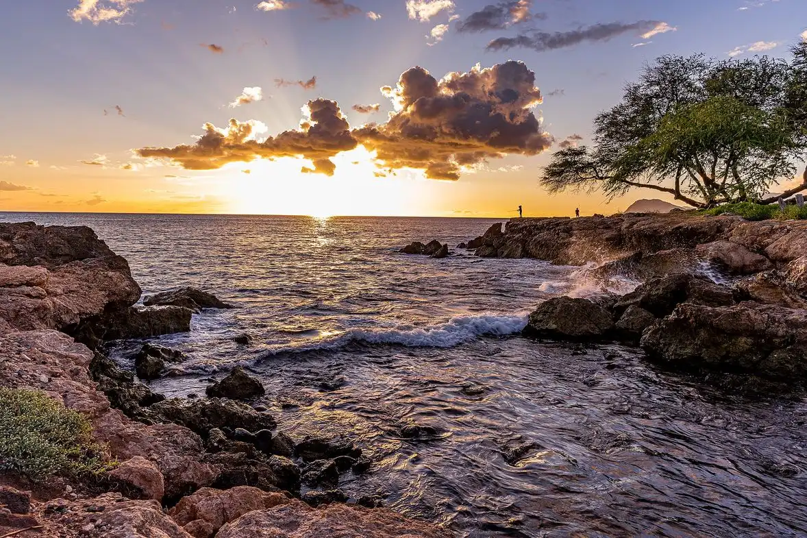 Sunset over a calm man-made lagoon and palms at Ko Olina resort on Oahu
