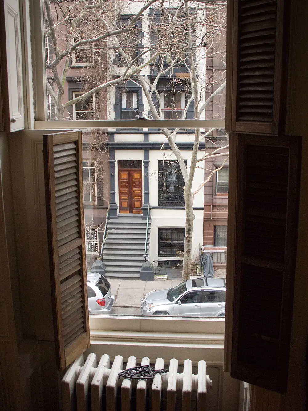 A row of brownstone townhouses with stoops on a residential Upper West Side street