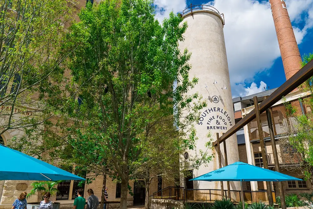 Southerleigh Fine Food and Brewery silo and turquoise patio umbrellas at Pearl District San Antonio