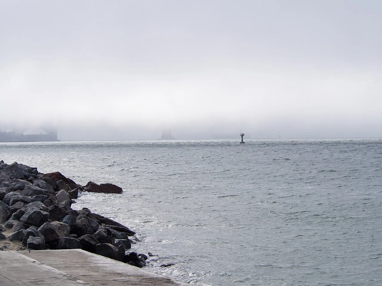 The Golden Gate Bridge half hidden by fog seen from near the Marina in San Francisco