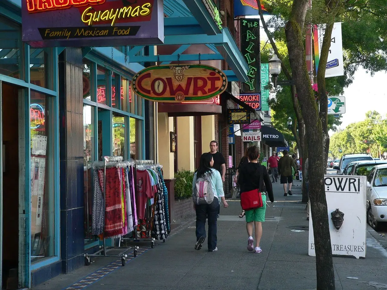 Pedestrians passing shop signs and awnings on Broadway on Capitol Hill in Seattle