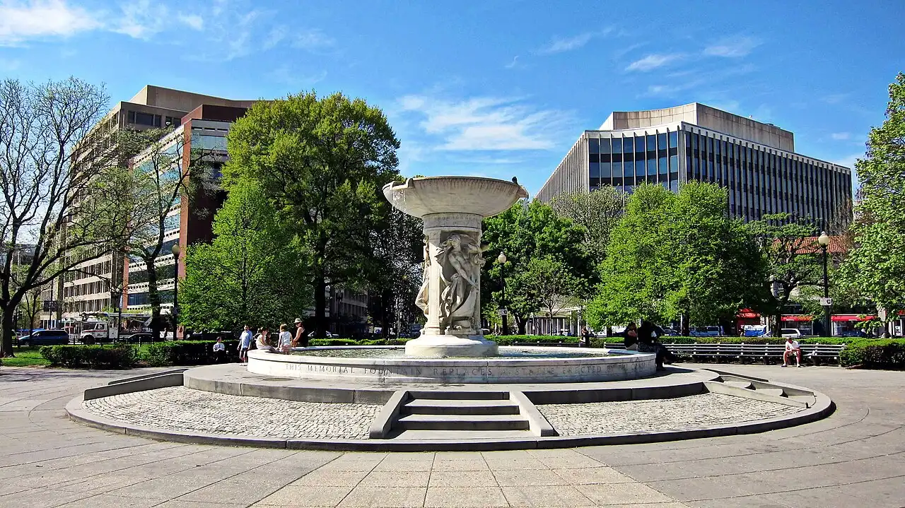 Dupont Circle fountain with apartment buildings and trees around the traffic circle