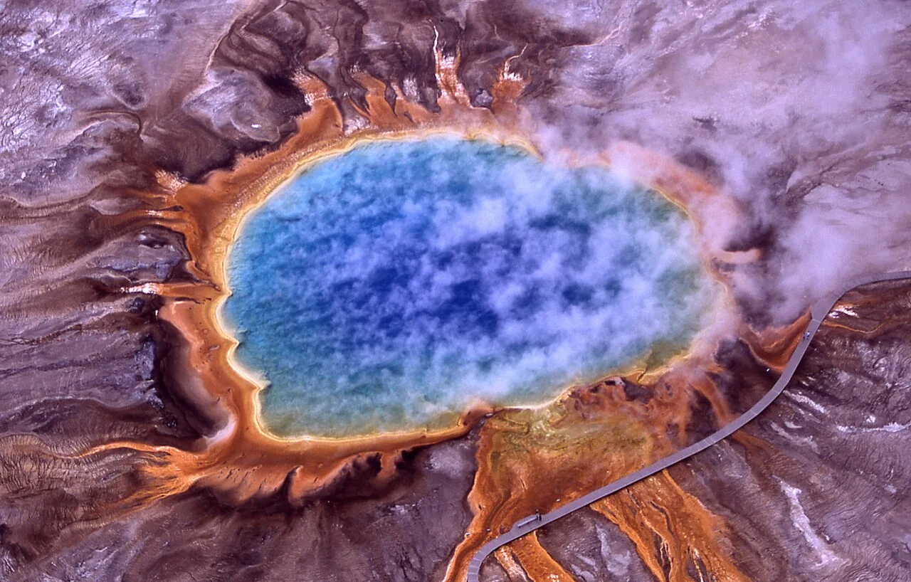 The orange, yellow and deep blue rings of Grand Prismatic Spring steaming in Midway Geyser Basin