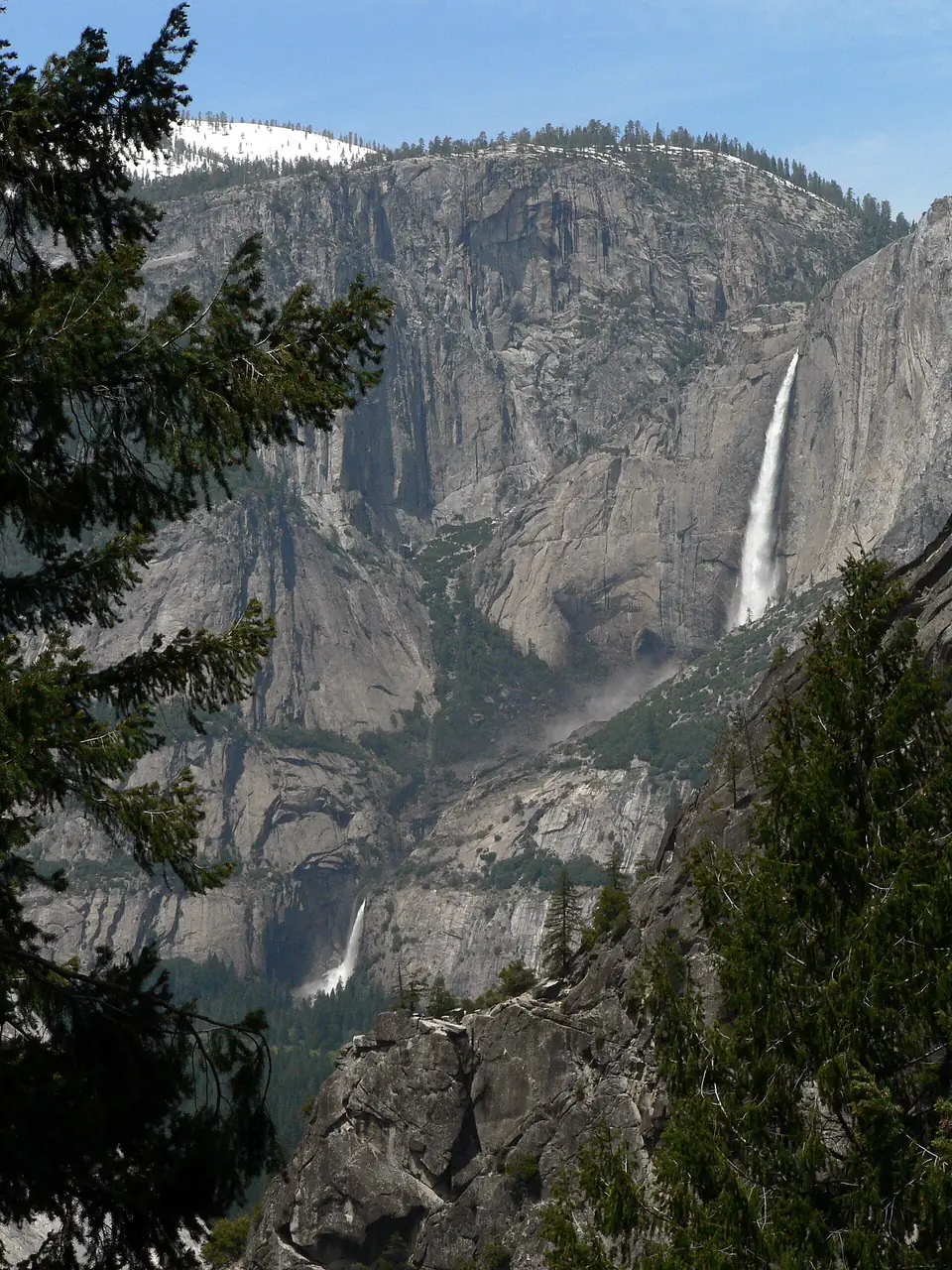Upper and Lower Yosemite Falls in full flow down a granite cliff above the valley floor